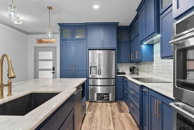 a kitchen with stainless steel appliances wooden cabinets a sink and a stove