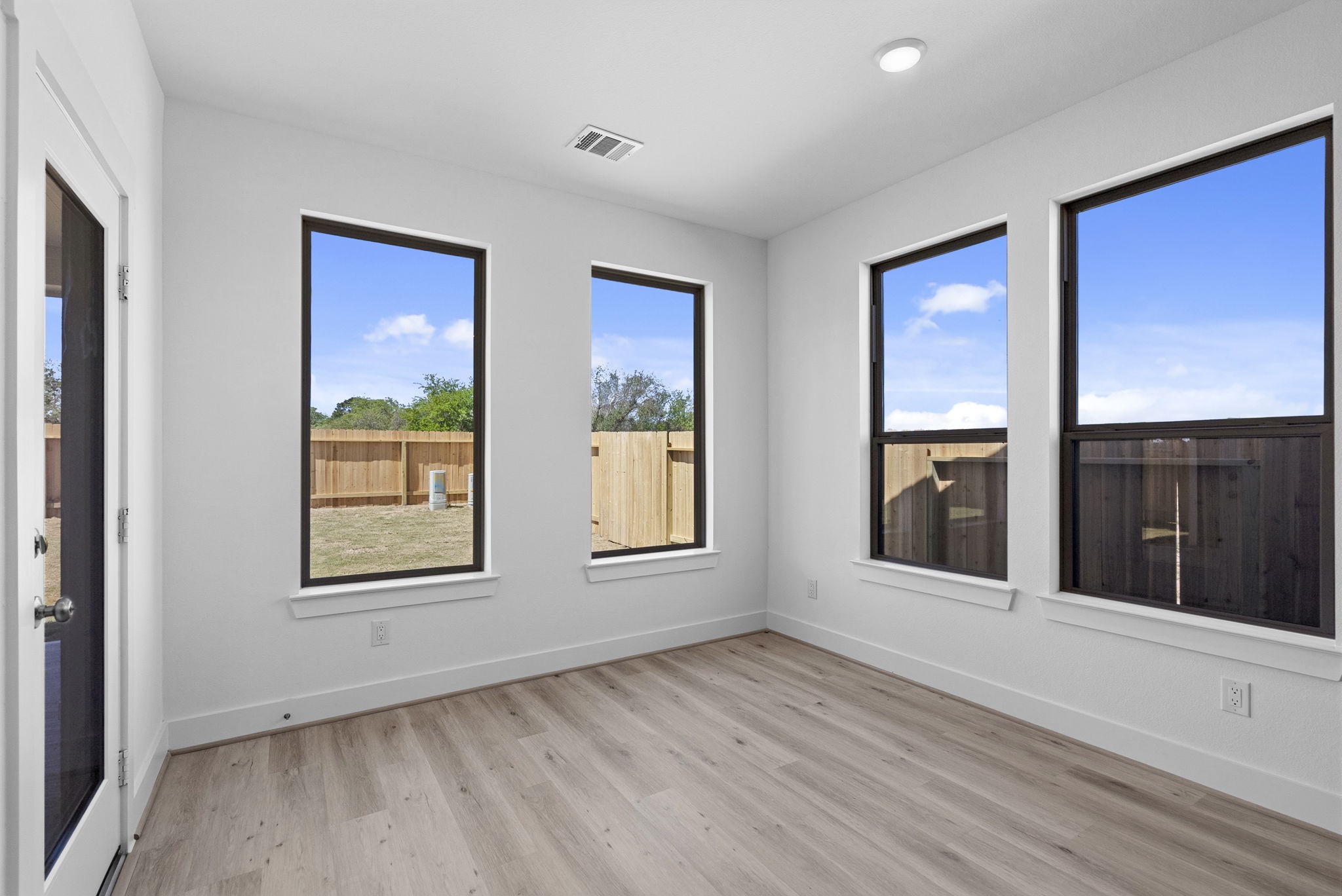 19211 Trinity Terrace Ln Spring Spring, TX 77379 - Photo 15 of 40 an empty room with wooden floor and windows