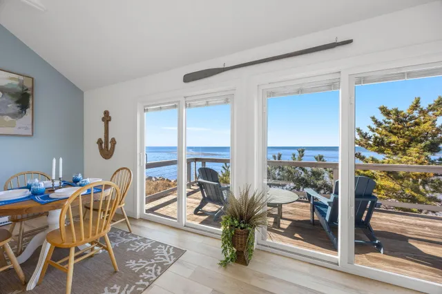 a dining room with furniture and a floor to ceiling window