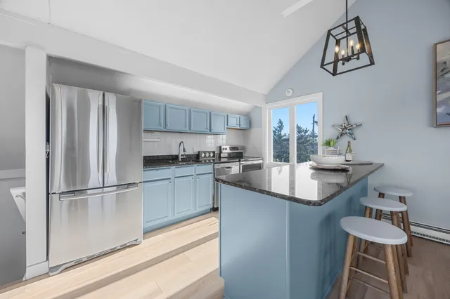 a kitchen with granite countertop a sink stainless steel appliances and cabinets