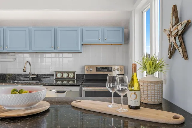 a kitchen with stainless steel appliances granite countertop a sink a stove and cabinets