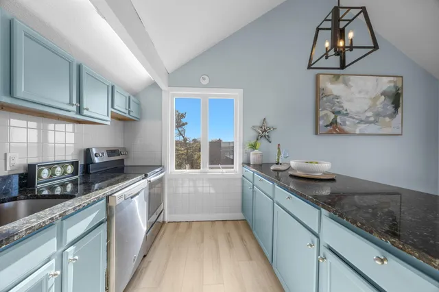 a kitchen with sink and view of living room