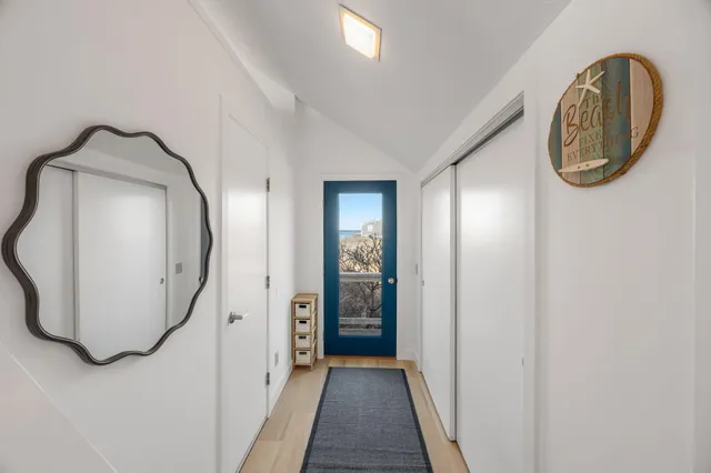 a view of a livingroom with wooden floor and a mirror