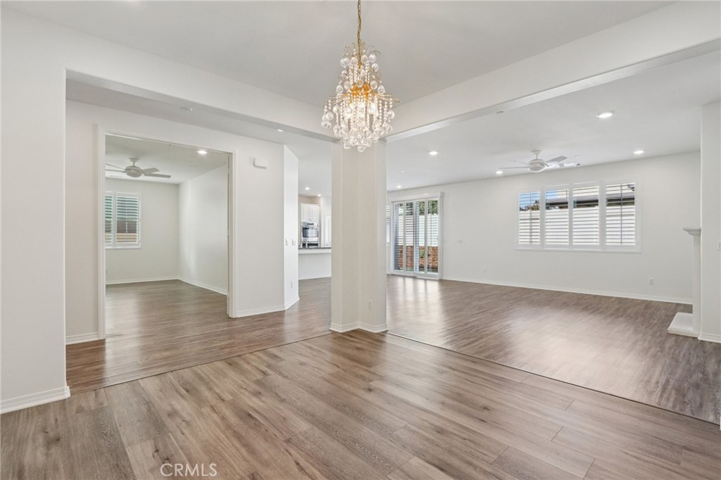 29594 Chelton Way Menifee, CA 92584 - Photo 12 of 48 a view of an empty room with wooden floor and a kitchen