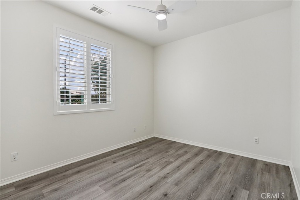 29594 Chelton Way Menifee, CA 92584 - Photo 28 of 48 an empty room with wooden floor and windows