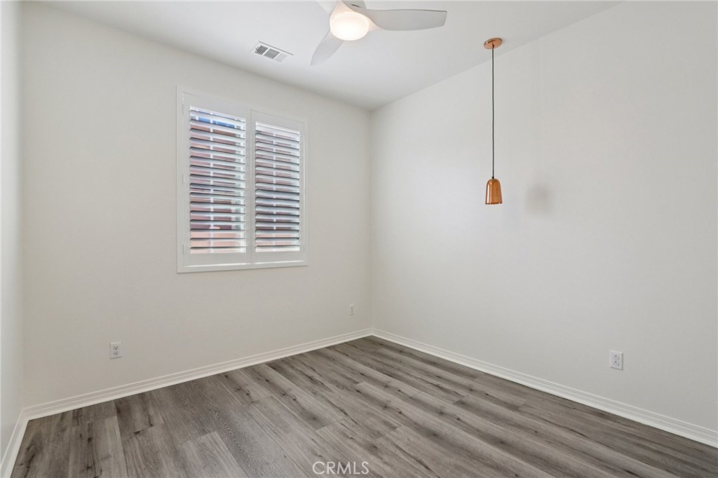 29594 Chelton Way Menifee, CA 92584 - Photo 30 of 48 a view of an empty room with wooden floor and windows