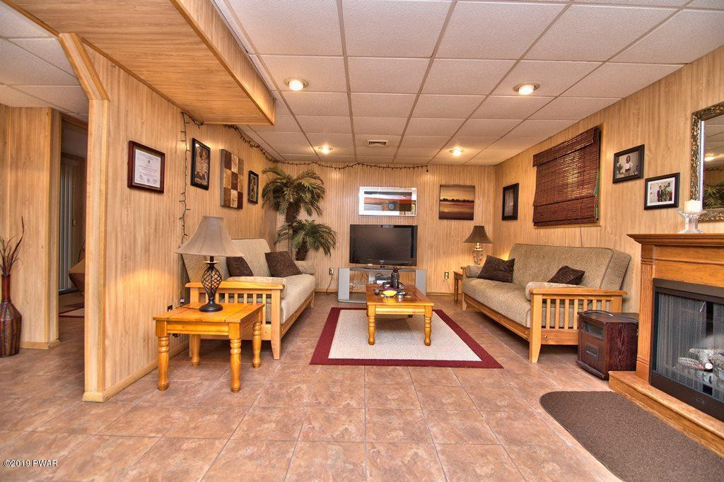 3151 Northgate Road Lake Ariel, PA 18436 - Photo 42 of 68 a living room with furniture a fireplace and a flat screen tv