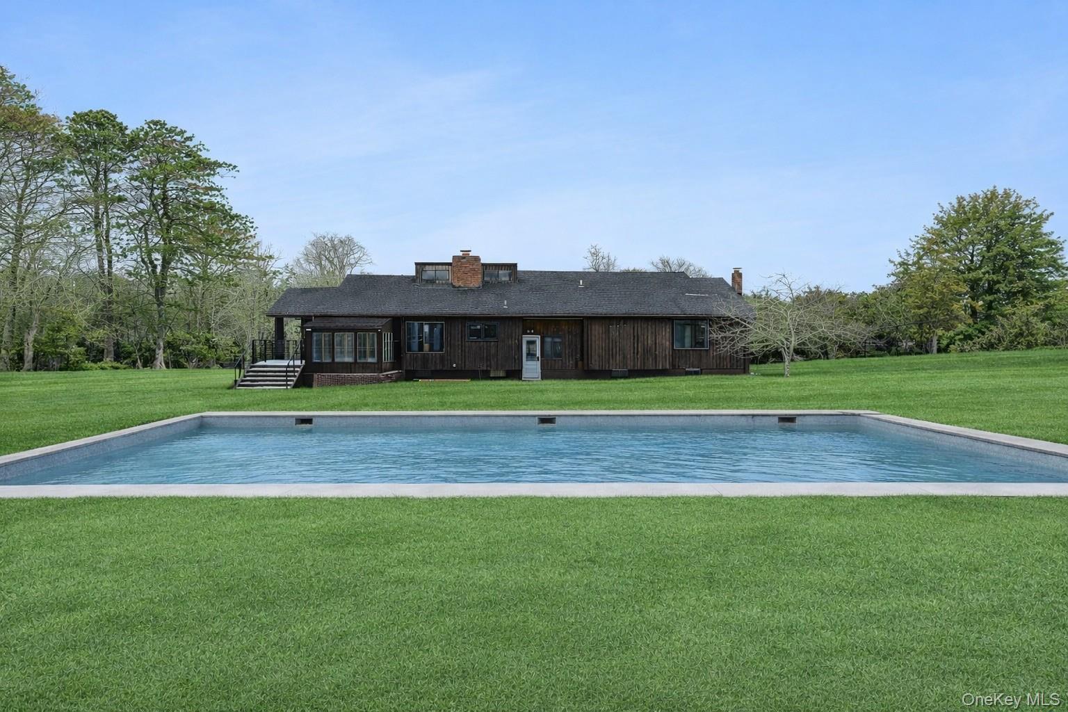 138 Longview Road Southampton, NY 11968 - Photo 13 of 13 a view of a big yard with table and chairs under an umbrella