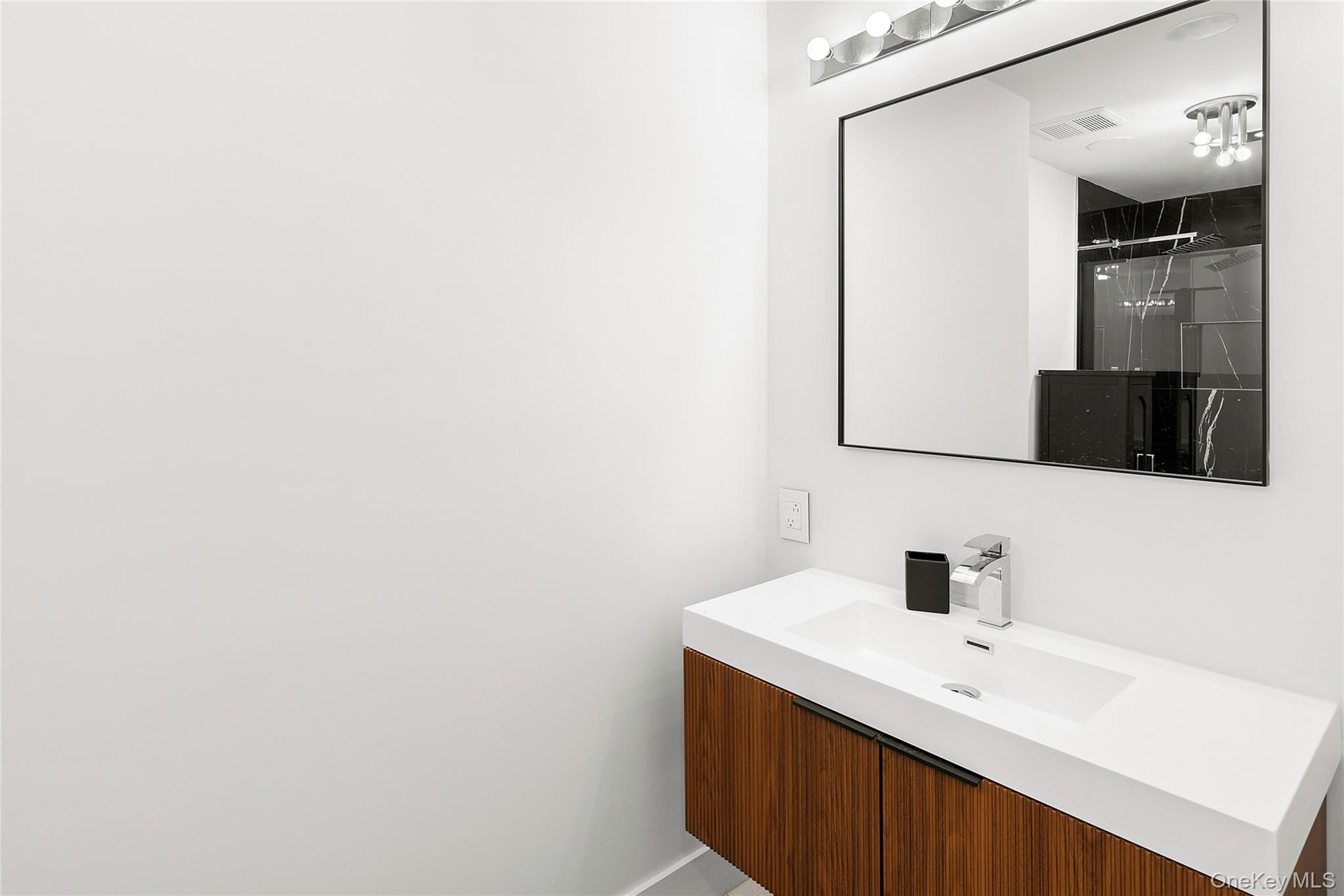 138 Longview Road Southampton, NY 11968 - Photo 10 of 13 a bathroom with a sink and a mirror