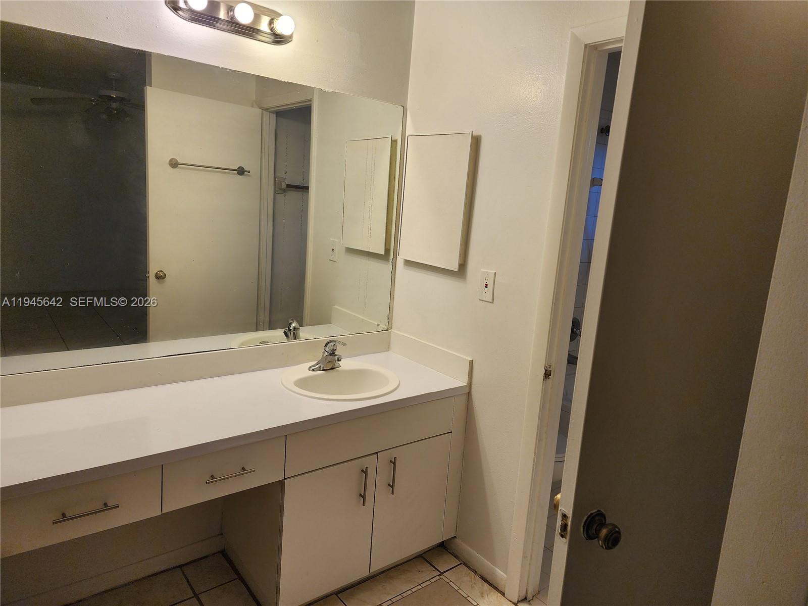 9863 Southwest 117th Place Miami, FL 33186 - Photo 18 of 29 a bathroom with a double vanity sink and mirror