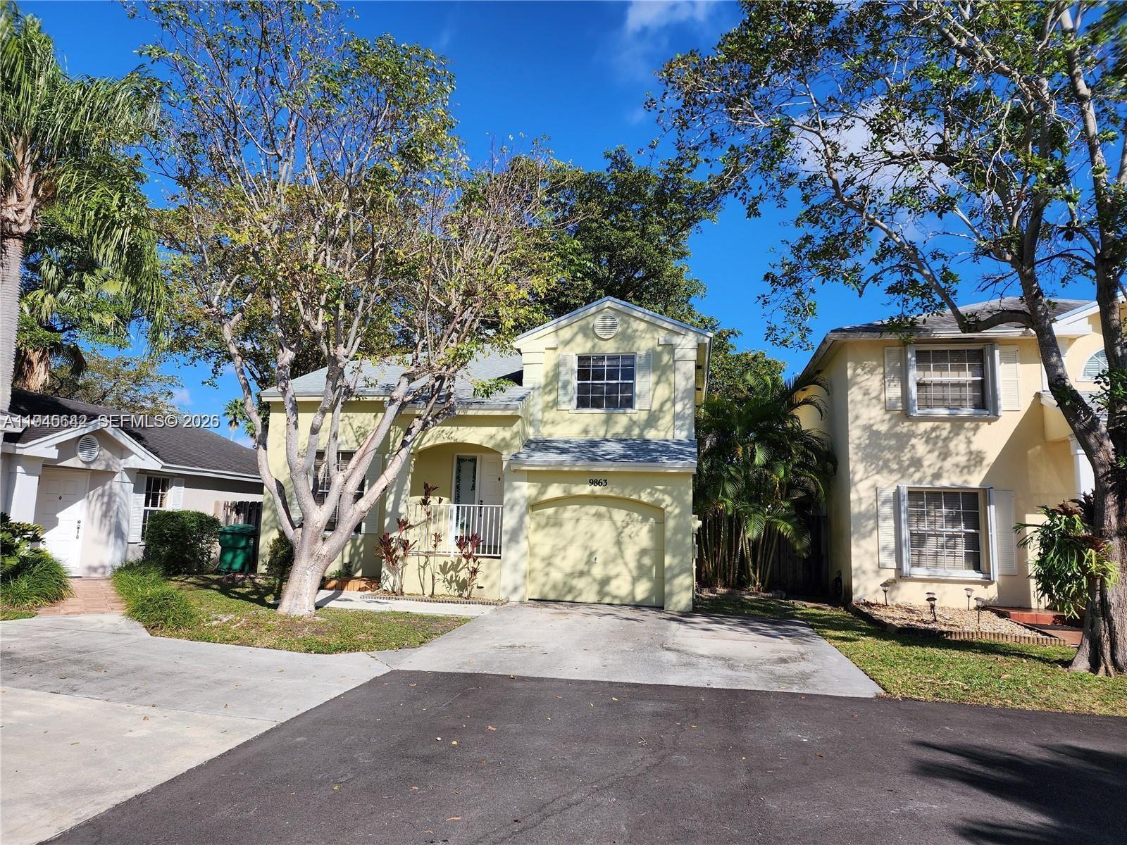 9863 Southwest 117th Place Miami, FL 33186 - Photo 2 of 29 a front view of a house with a yard and garage