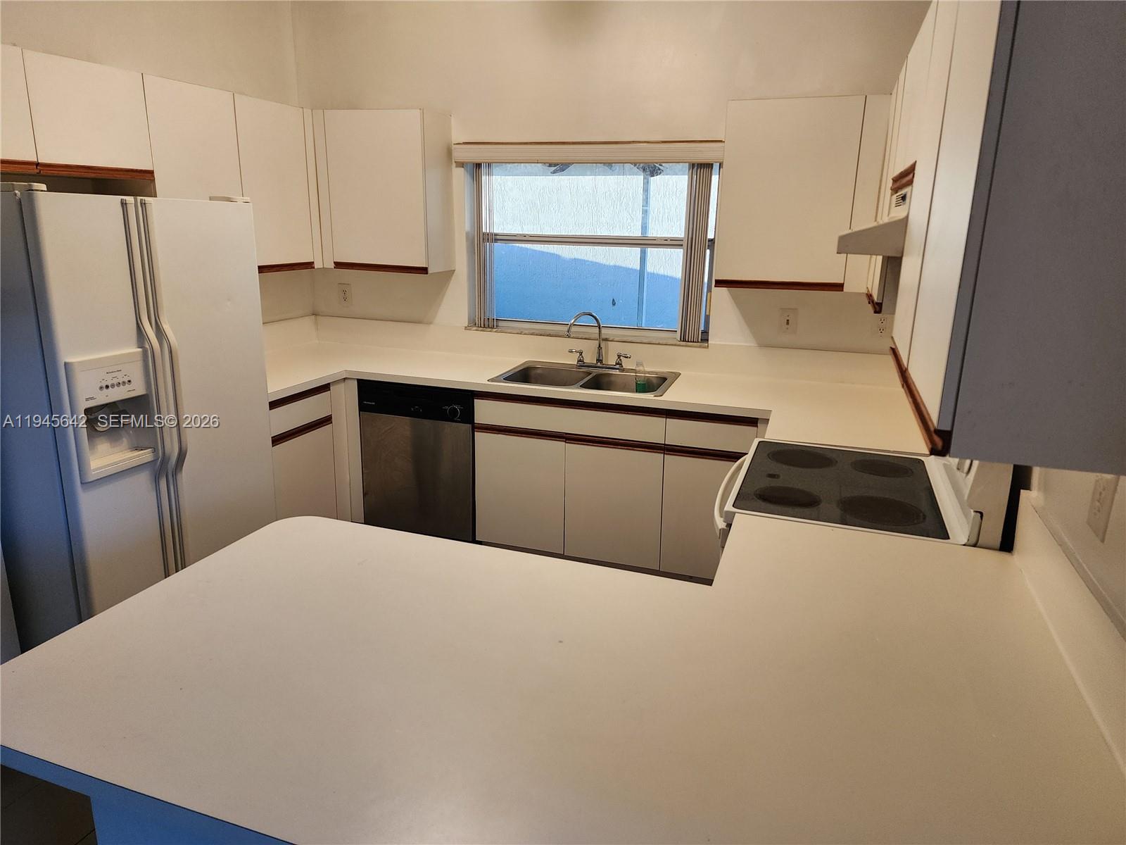 9863 Southwest 117th Place Miami, FL 33186 - Photo 6 of 29 a kitchen with stainless steel appliances a sink a stove a refrigerator and a window