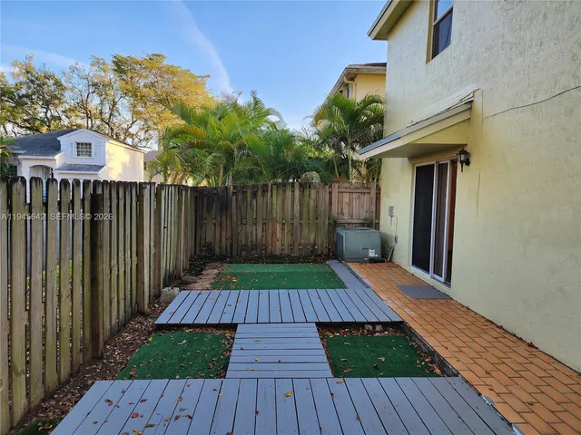 a view of an empty room with window and chandelier fan