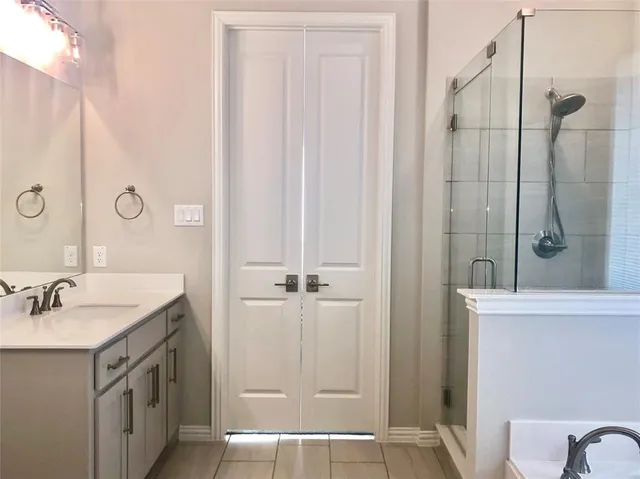 a bathroom with a double vanity sink a mirror and a shower