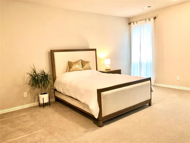 a bedroom with a bed and a potted plant