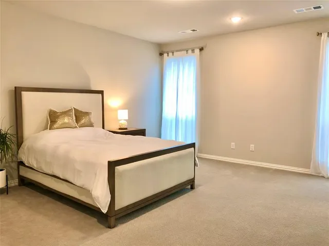 a bedroom with a bed and a night stand
