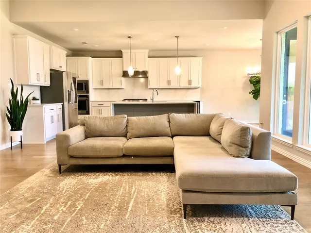 a living room with furniture wooden floor and a large window
