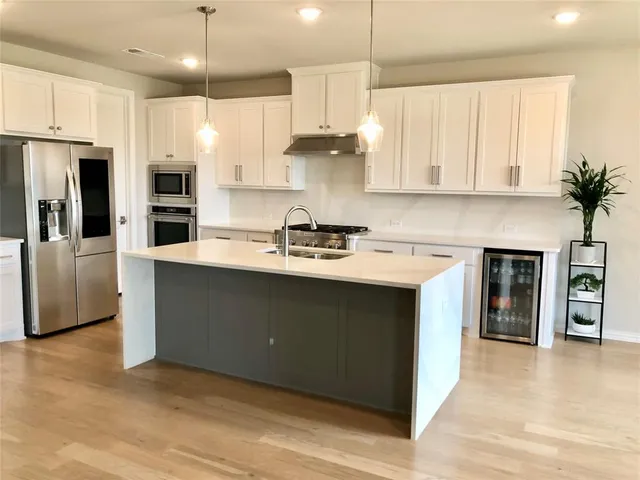 a kitchen with stainless steel appliances granite countertop a sink a stove and a refrigerator