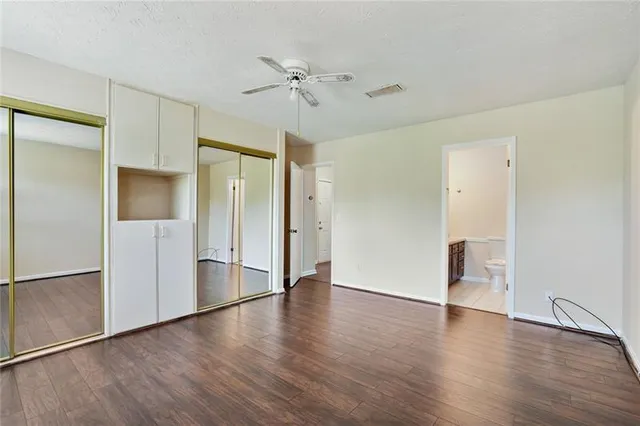 an empty room with wooden floor and cabinet