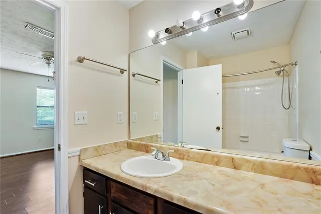 a bathroom with a granite countertop double vanity sink and mirror