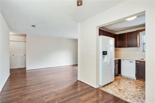 a view of a kitchen with refrigerator and wooden floor