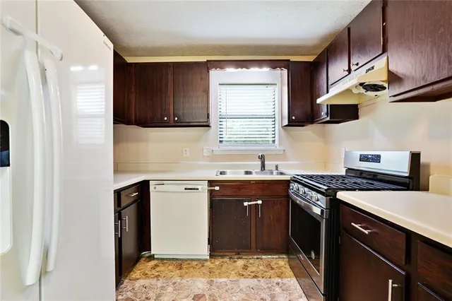 a kitchen with stainless steel appliances granite countertop a sink stove and refrigerator