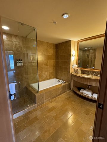 a bathroom with a granite countertop bathtub shower sink and mirror
