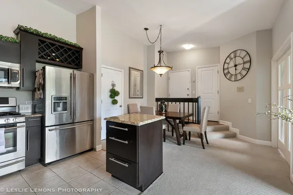 a kitchen with stainless steel appliances granite countertop a refrigerator a stove and a refrigerator with wooden floor