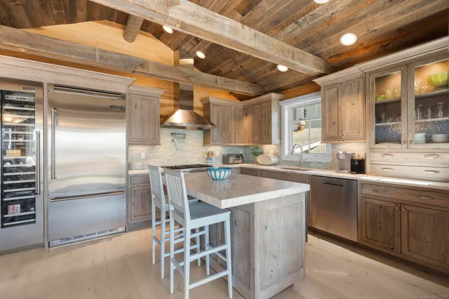 a kitchen with stainless steel appliances granite countertop a sink a stove and a refrigerator