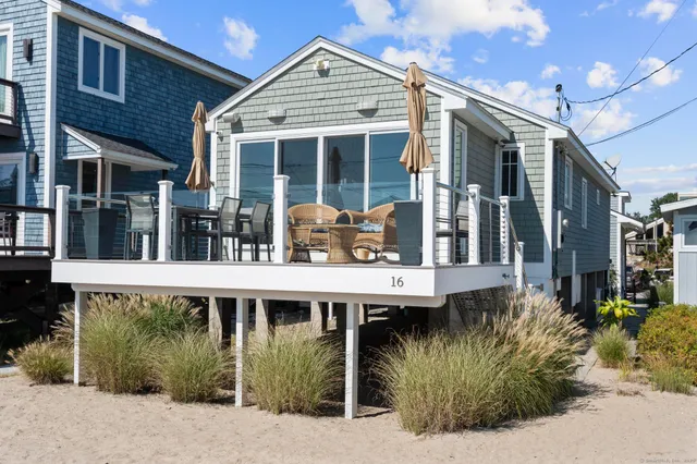 a view of a house with large windows and plants