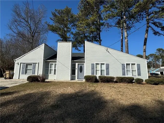 a front view of a house with a yard and trees