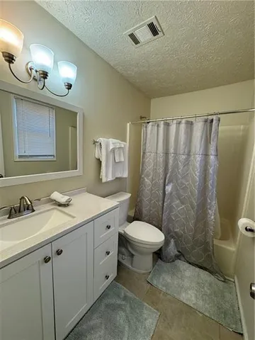 a bathroom with a granite countertop sink toilet and a mirror
