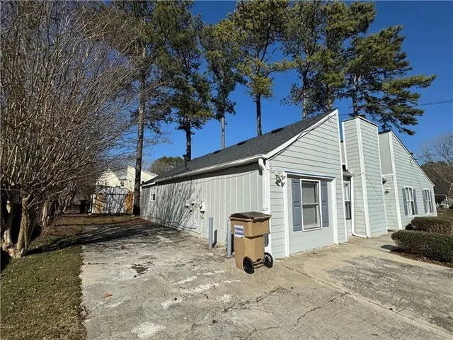 a view of a house with a yard and large tree