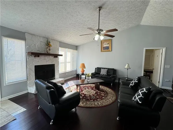 a living room with furniture a fireplace and a flat screen tv