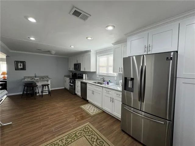 a kitchen with stainless steel appliances granite countertop a refrigerator and a stove top oven