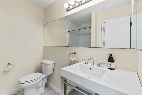 a bathroom with a sink toilet and mirror