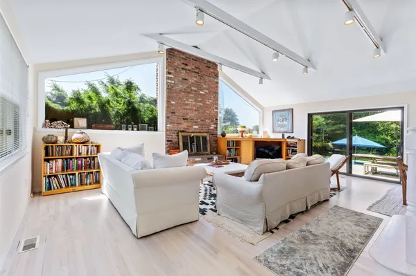 a living room with furniture wooden floor and a large window