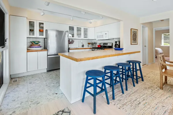 a kitchen with stainless steel appliances granite countertop a refrigerator and a stove top oven