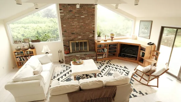 a living room with furniture a fireplace and a floor to ceiling window