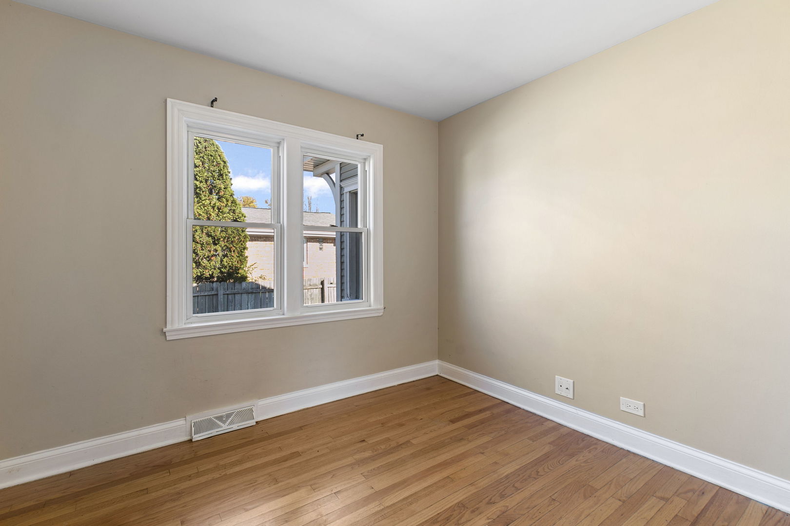 8152 Mayfield Avenue Burbank, IL 60459 - Photo 14 of 21 a view of an empty room with wooden floor and a window