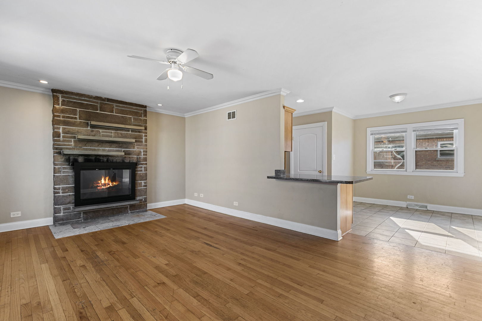 8152 Mayfield Avenue Burbank, IL 60459 - Photo 6 of 21 a view of empty room with wooden floor and fireplace