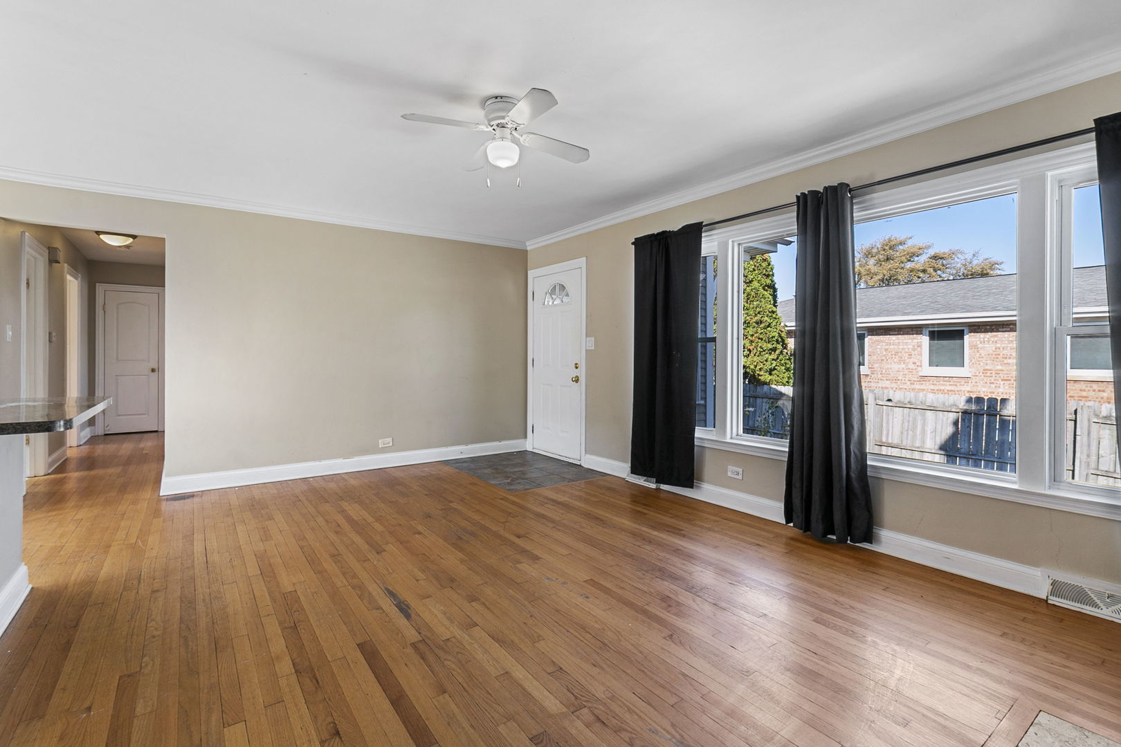 8152 Mayfield Avenue Burbank, IL 60459 - Photo 7 of 21 a view of an empty room with a window and wooden floor
