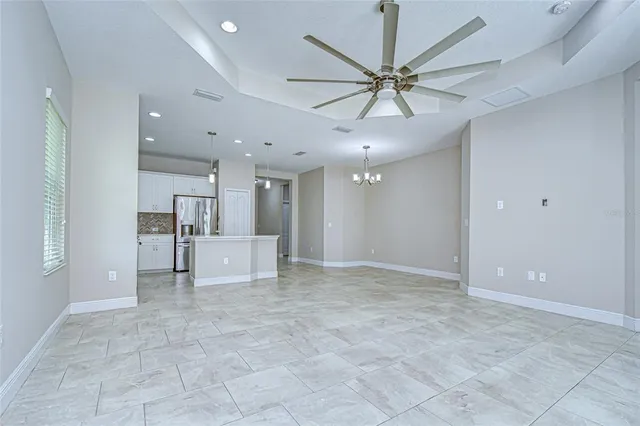 an empty room with a window and a fan