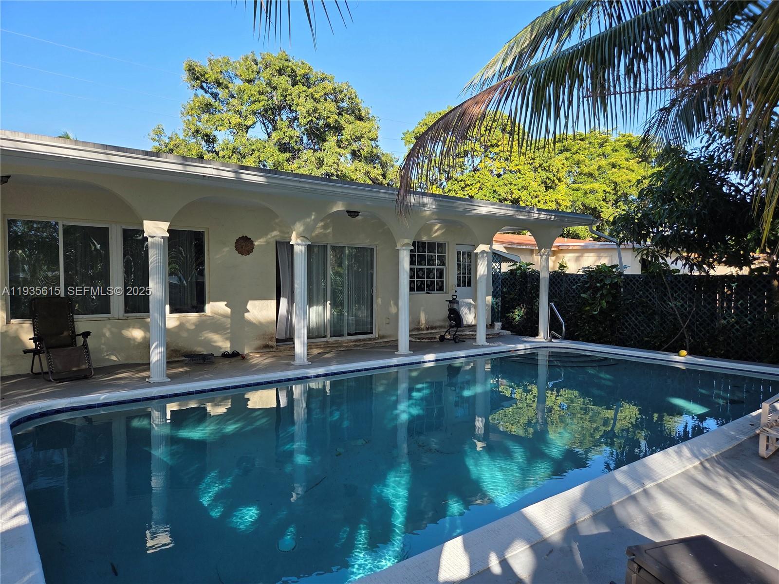 a view of a house with swimming pool and sitting area