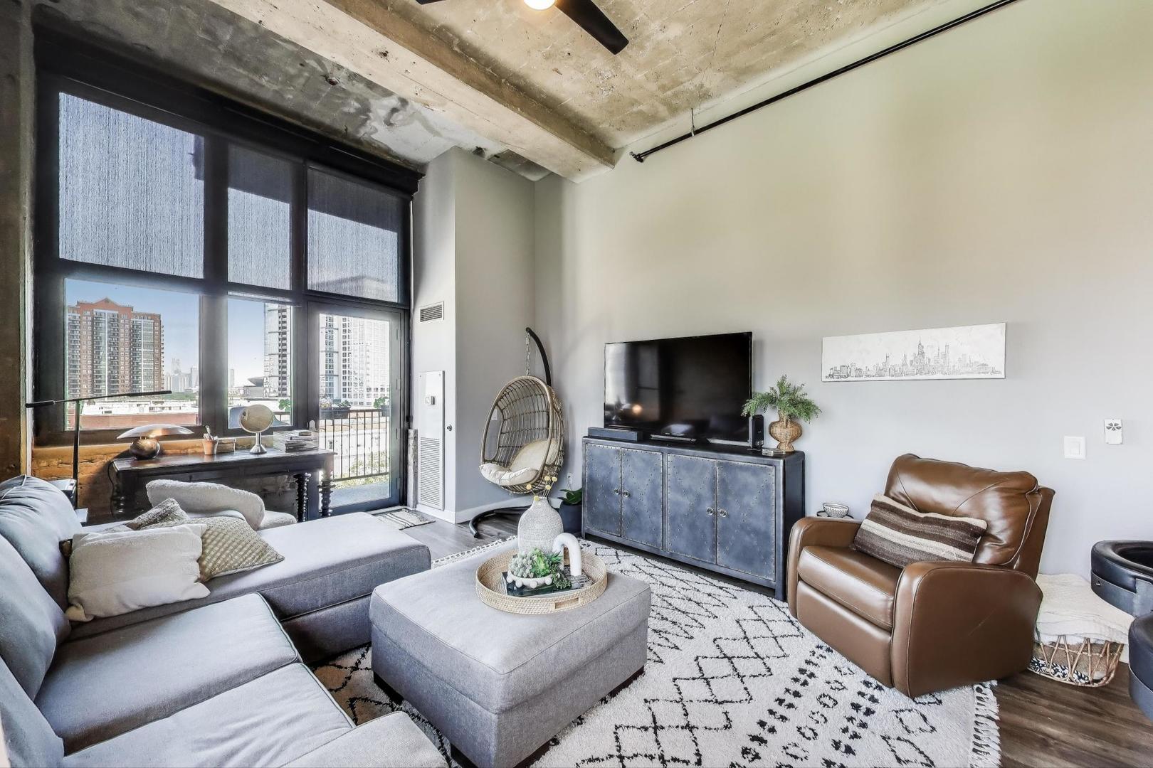 320 East 21st Street, Unit 501 Chicago, IL 60616 - Photo 3 of 22 a living room with furniture a flat screen tv and a large window