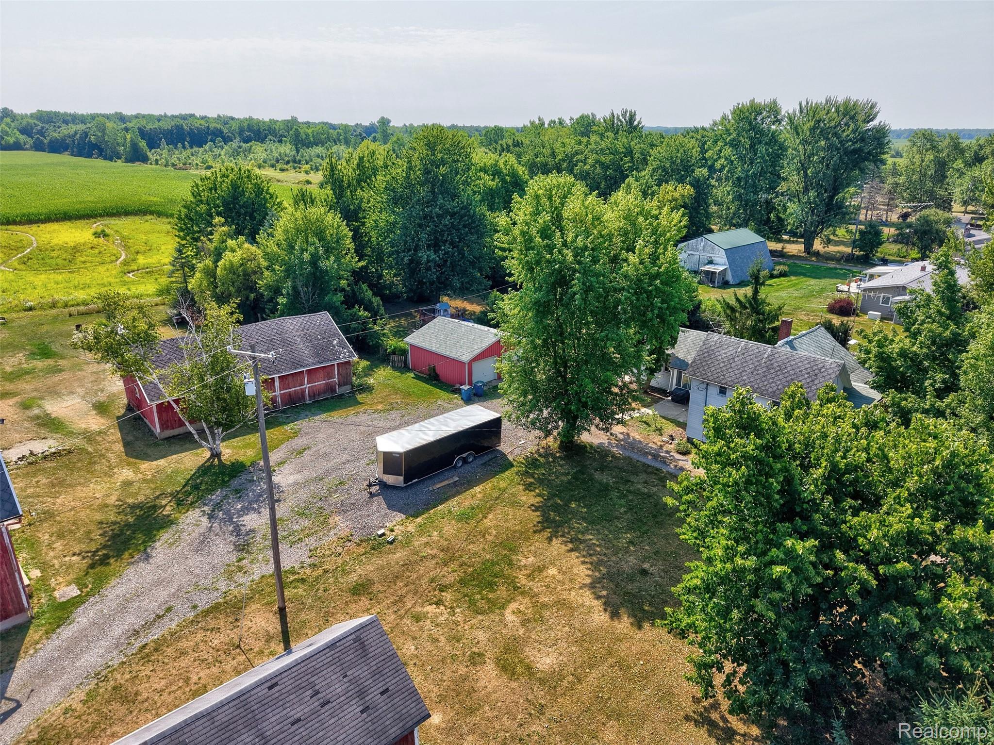 1175 South Morrish Road Flint, MI 48532 - Photo 64 of 72 Multiple red-sided outbuildings with white trim, gravel driveways, and expansive green spaces