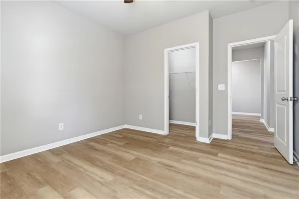 an empty room with wooden floor & closet area