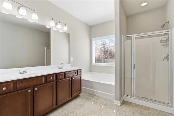 a spacious bathroom with a tub sink shower and mirror