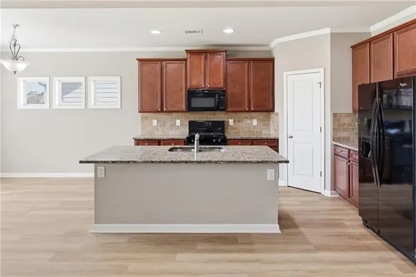 a kitchen with stainless steel appliances granite countertop a stove a sink and a refrigerator