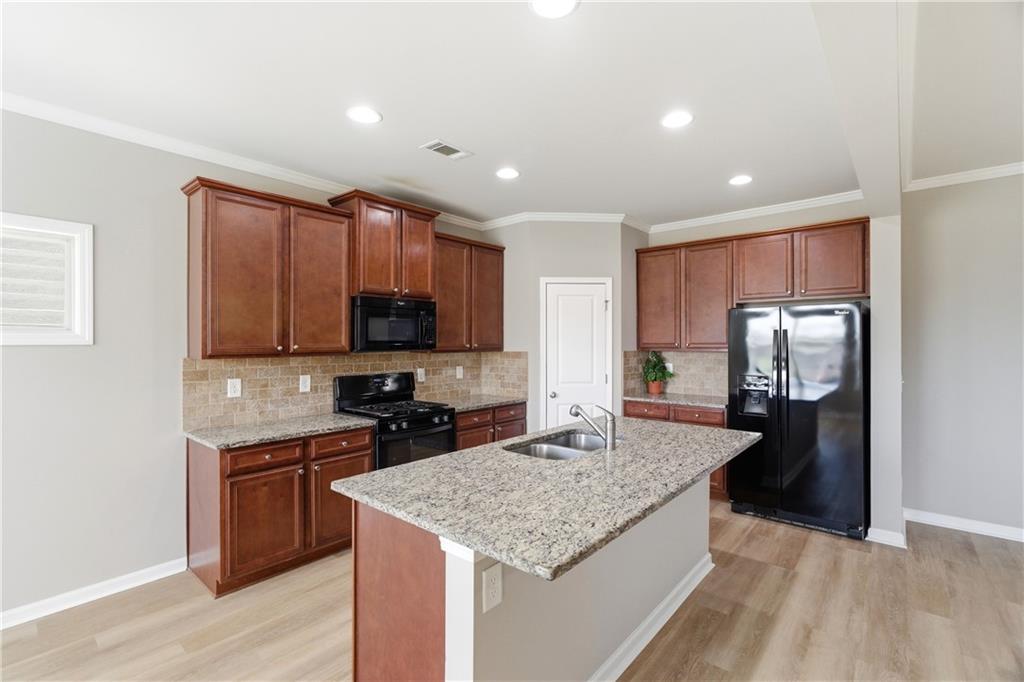 4479 Clubside Drive Gainesville, GA 30504 - Photo 32 of 47 a kitchen with stainless steel appliances granite countertop a sink refrigerator and microwave